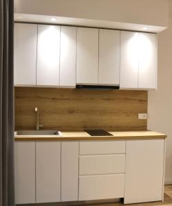 uma cozinha com armários brancos e um lavatório em David's Studio Stays em Vlorë
