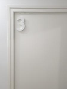 a white door with the number three on it at La green in Brétigny-sur-Orge