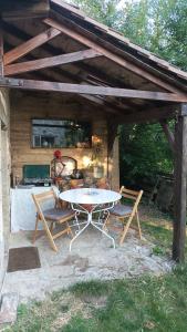 a patio with a table and two chairs and a grill at Chambre insolite in Saint-Mathieu