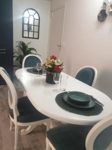 a white table with chairs and a white table with plates and glasses at La green in Brétigny-sur-Orge +15 photos