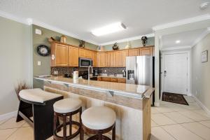 a kitchen with a large counter and a refrigerator at PARKING INCLUDED-Beachfront 2BD Ocean Villa! Gorgeous Amenities, Private Complex in Panama City Beach
