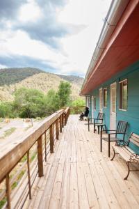 una terraza de madera con bancos en una casa en Cloudcroft Hostel, en Cloudcroft