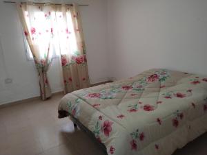 a bedroom with a bed with flowers on it at Casa de campo los algarrobos 
