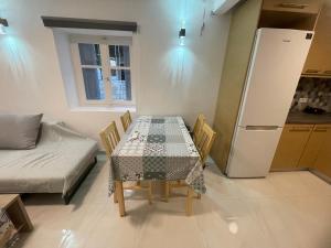 uma sala de jantar com uma mesa e um frigorífico em Coco Luxury Apartments em Poros