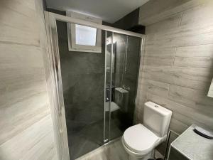 a bathroom with a toilet and a glass shower at Coco Luxury Apartments in Poros