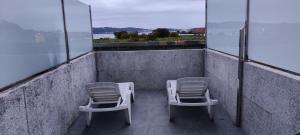 two chairs and a table on a balcony at Dena-Sol in Meaño