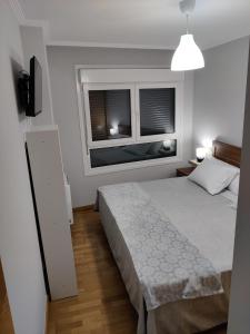 ein Schlafzimmer mit einem großen Bett und zwei Fenstern in der Unterkunft Dena-Sol in Meaño