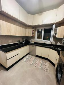 una cocina con armarios blancos y una alfombra en el suelo en Appartement jade en Esauira