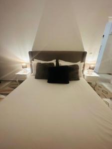 a large white bed with two nightstands and two tables at Appartement jade in Essaouira