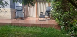 twee stoelen op een patio naast een gebouw bij amicale ilyass beach sidi rhal in Dar Hamida