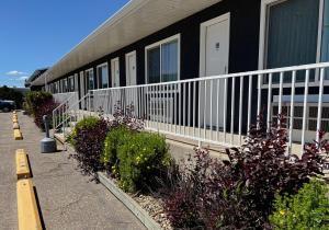a building with a balcony and some bushes and flowers at Coast Swift Current Hotel in Swift Current