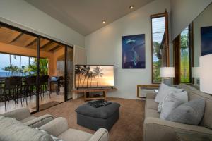 a living room with a large tv and a couch at Wailea Ekahi Village - CoralTree Residence Collection in Wailea