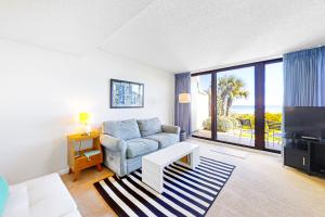 a living room with a couch and a large window at Captains Court 1031 in Fernandina Beach