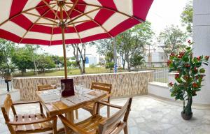 - une table avec un parasol rouge et blanc sur la terrasse dans l'établissement HOTEL BOUTIQUE LUXURY, à Cali