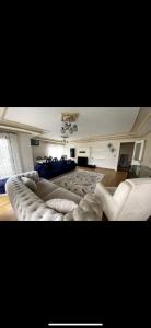 ein Wohnzimmer mit einem Sofa und 2 weißen Stühlen in der Unterkunft Nadide sokak daire4 dublex in Istanbul