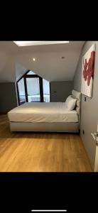 ein großes weißes Bett in einem Zimmer mit Holzböden in der Unterkunft Nadide sokak daire4 dublex in Istanbul