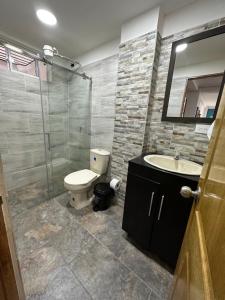 a bathroom with a toilet and a sink and a shower at Apartamentos La Gloria Guatapé in Guatapé