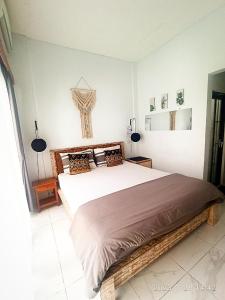 a bedroom with a large bed and two lamps at Loka Anyar Guest House in Kerobokan