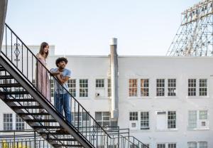 Ein Mann und eine Frau stehen auf einer Treppe vor einem Gebäude in der Unterkunft Park Lane Suites & Inn in Portland