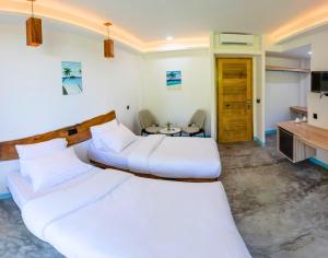 a hotel room with two beds and a table at Silver County Hotel, Fuvahmulah - Maldives in Fuvahmulah