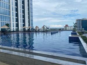 a large swimming pool next to a tall building at Galeno Pollux Habibie in Batam Center