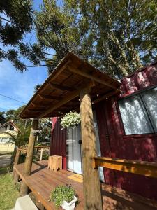 a cabin with a wooden deck with a roof at Recanto das Gralhas in São Francisco de Paula