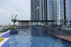 a pool in the middle of a city with tall buildings at Galeno Pollux Habibie in Batam Center