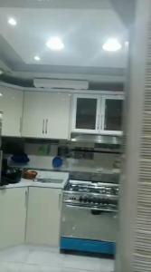 een keuken met witte kasten en een fornuis met oven bij HousRom in Caïro