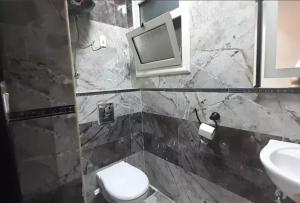 een badkamer met een toilet, een wastafel en een spiegel bij HousRom in Caïro