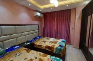een slaapkamer met 2 bedden en een rood gordijn bij HousRom in Caïro
