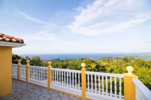 Elle comprend un balcon offrant une vue sur l'océan. dans l'établissement Round View Guest House, à Port Antonio