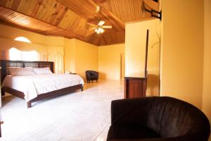 a bedroom with a bed and a chair in it at Round View Guest House in Port Antonio