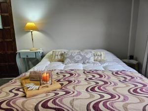 Una cama con una mesa con una vela. en Samambaias, en Puerto Iguazú