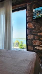 a bedroom with a window with a view of the ocean at RUSTICO in Široka