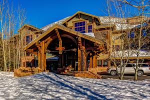 une maison en rondins dans la neige avec une voiture garée devant dans l'établissement The Lodges at Deer Valley 3 Units, à Park City