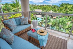 Un balcón con sofá y un sombrero en una mesa. en Ho Olei Residences - CoralTree Residence Collection, en Wailea