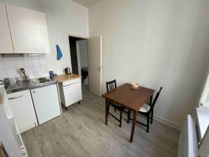 a small kitchen with a wooden table and a dining room at Appartement lumineux et central in Nantes
