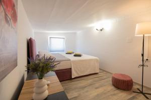 Cette petite chambre blanche comprend un lit et une table. dans l'établissement Family friendly house with a parking space Imotski, Zagora - 21150, à Podbablje