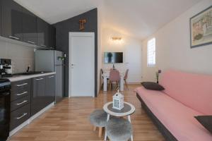 un salon avec un canapé rose et une table dans l'établissement Family friendly house with a parking space Imotski, Zagora - 21150, à Podbablje