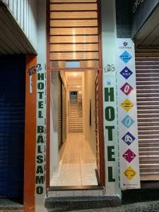a hallway of a building with a door and signs at BALSAMO HOTEL in Marília