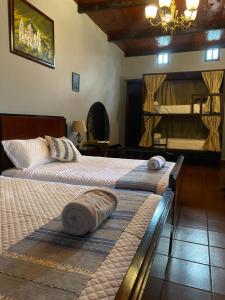 een slaapkamer met 2 bedden en handdoeken bij RUAJ HOSTAL -Wellness-Colonial-Exclusive- in Antigua Guatemala