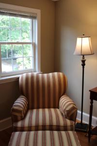 uma cadeira num quarto com um candeeiro e uma janela em The Emory House em Emory
