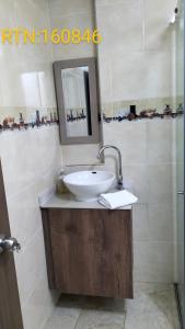 y baño con lavabo y espejo. en Apartamento Family 3, en Santa Rosa de Cabal