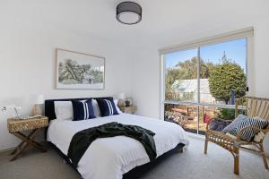 カウズにあるSeaview Cowes by Ready Set Stayのベッドと大きな窓のある寝室