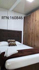 a bedroom with a large bed with a wooden headboard at Apartamento Family 3 in Santa Rosa de Cabal