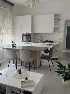 a kitchen with white cabinets and a table and chairs at Pash apartment in Pero