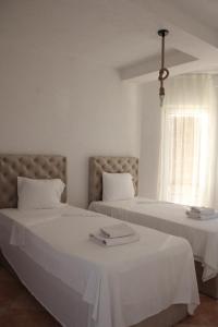 een slaapkamer met 2 bedden met witte lakens en een raam bij Egnatia Apartments in Struga