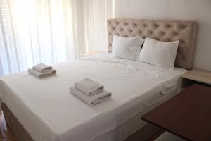 een wit bed met twee handdoeken erop bij Egnatia Apartments in Struga