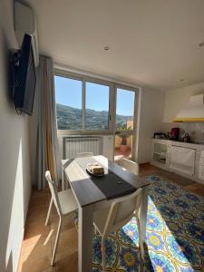 un soggiorno con tavolo e una grande finestra di Sirenai Apartment a Colli di Fontanelle
