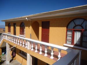 a balcony of a house with a staircase at Hostal del Sol Isla del Sol in Isla de Sol